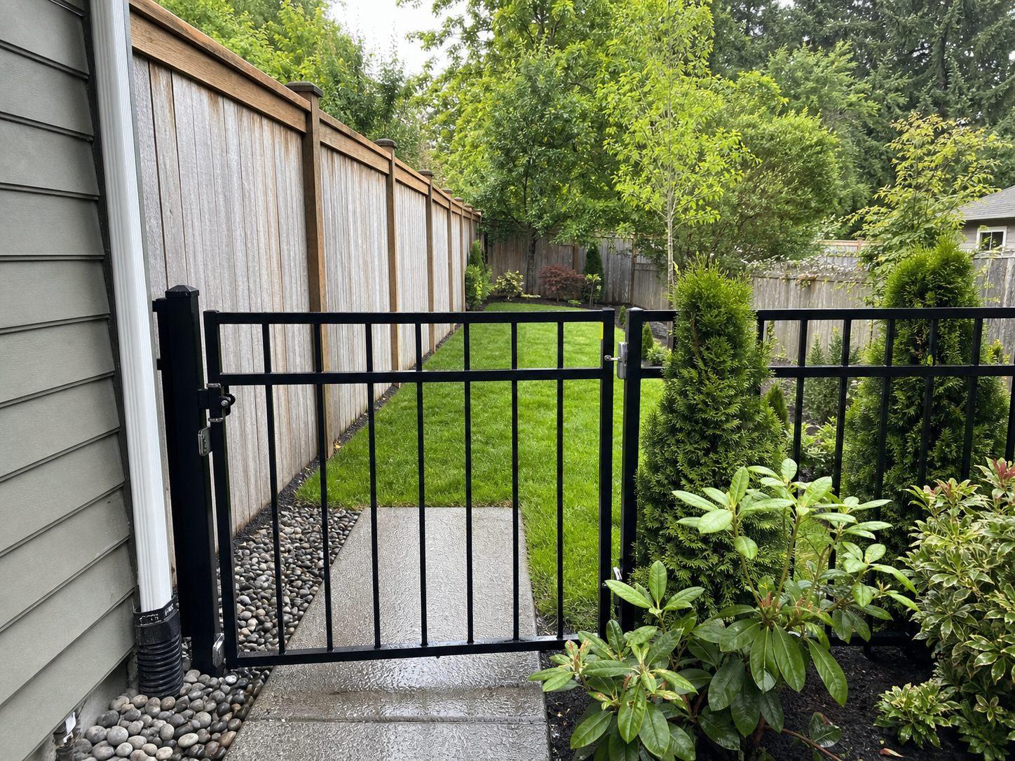 Compact Cascade Park fenced yard with clean grass, concrete path, and a small dog